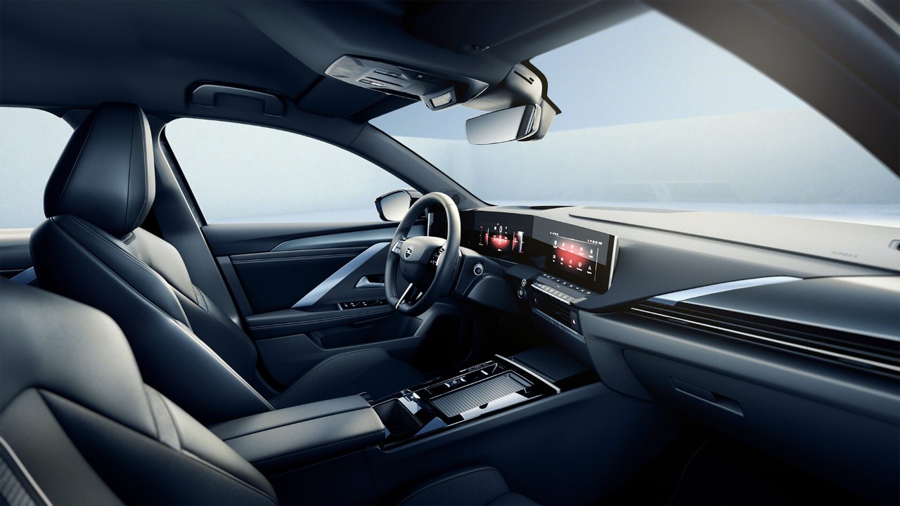 Közelkép az új Opel Astra Sports Tourer első üléséről és kormánykerekéről, fekete belső térben