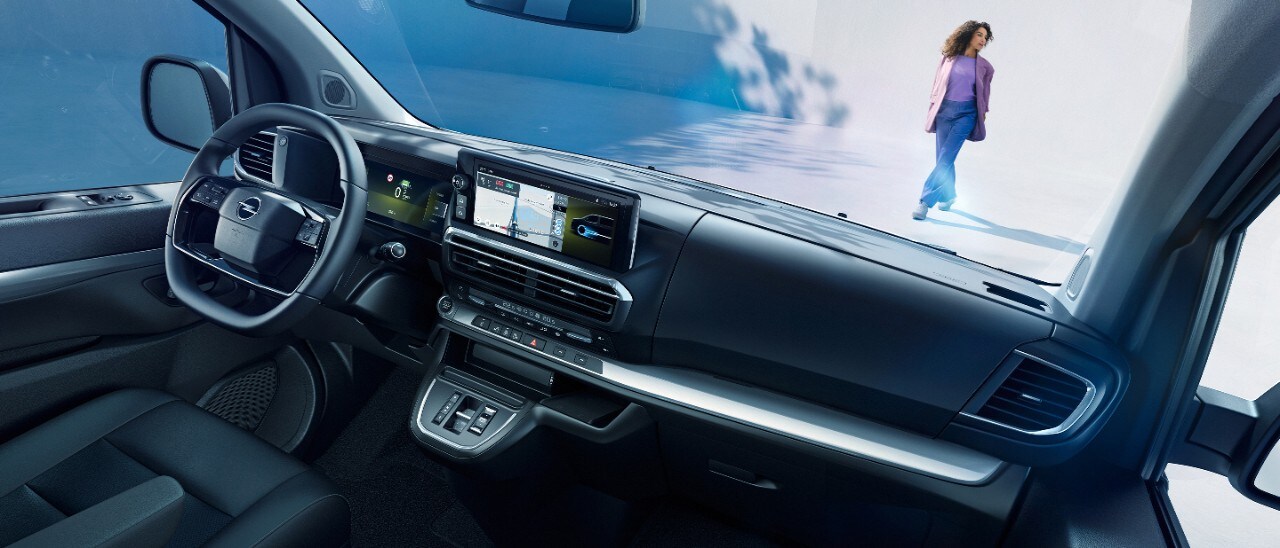 Egy fehér Opel Zafira Electric belső terének nézete az utasülésből, egy kint álló nővel