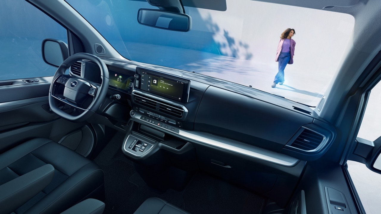 Egy fehér Opel Zafira belső terének nézete az utasülésből, egy kint álló nővel