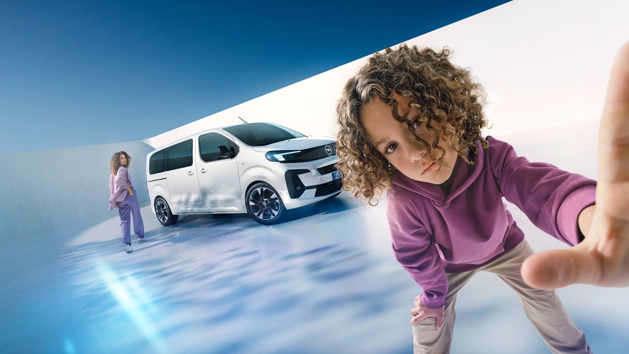 Nő és fiú egy fehér Opel Zafirával a háttérben